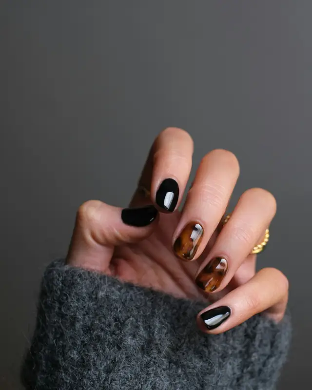 Mano con uñas pintadas en negro y marrón, foto de ejemplo