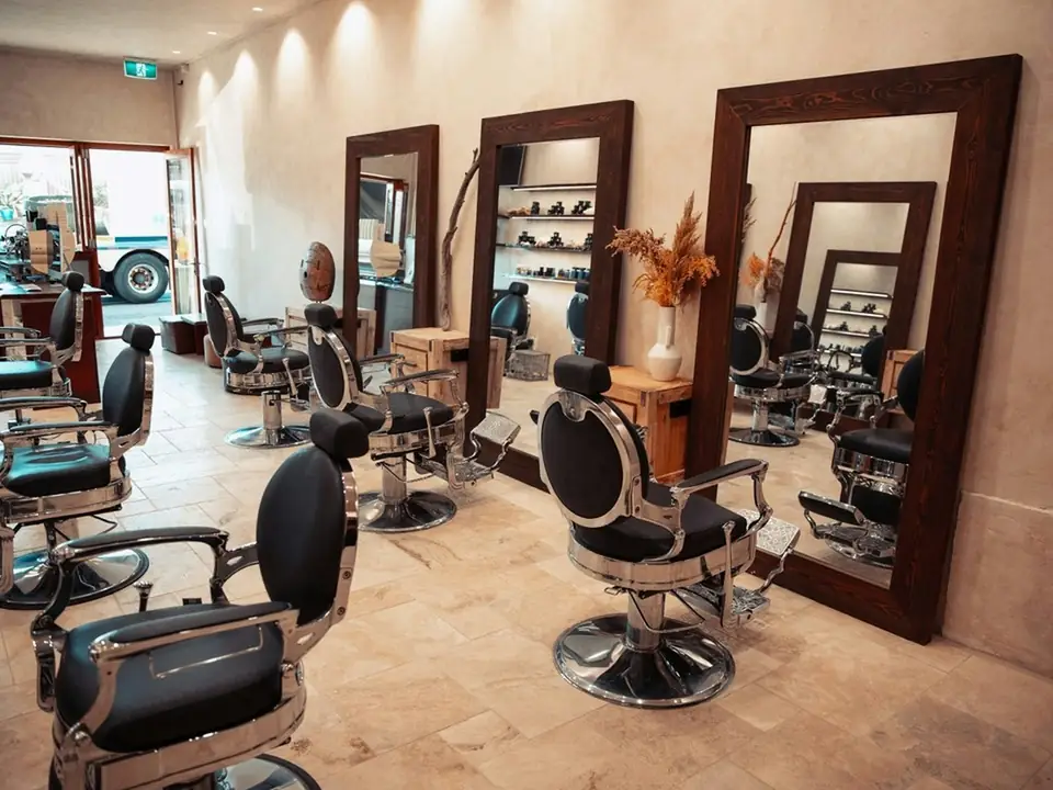 Barbería con sillones y grandes espejos, foto de ejemplo