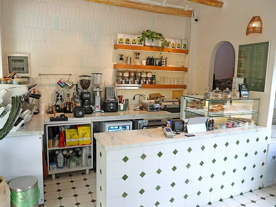 Barra de una cafetería con vitrina y máquinas de café, foto de ejemplo