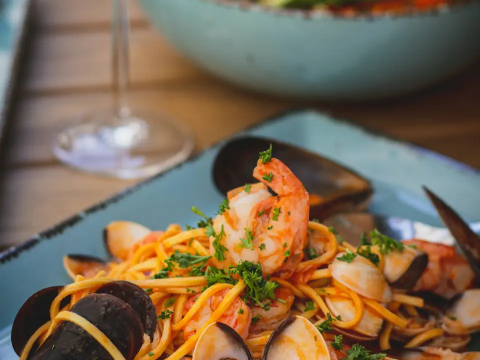 Plato de pasta con marisco sobre una mesa, foto de ejemplo