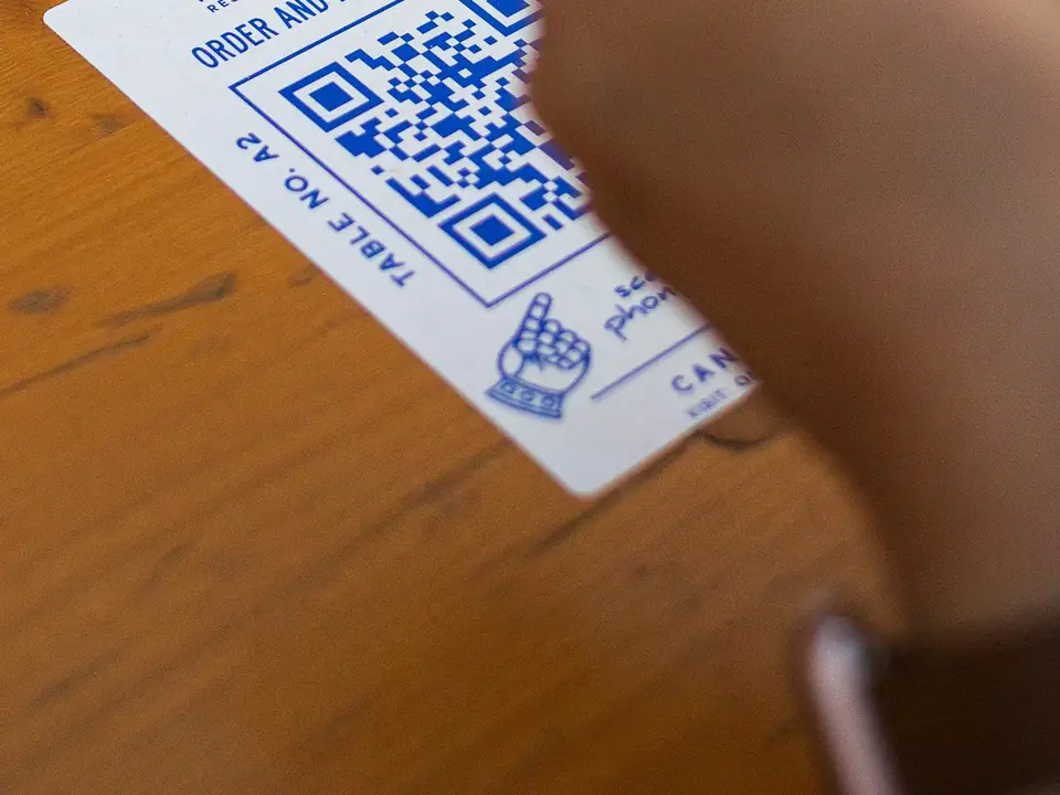 Cliente escaneando el QR de una mesa con el celular, foto de ejemplo