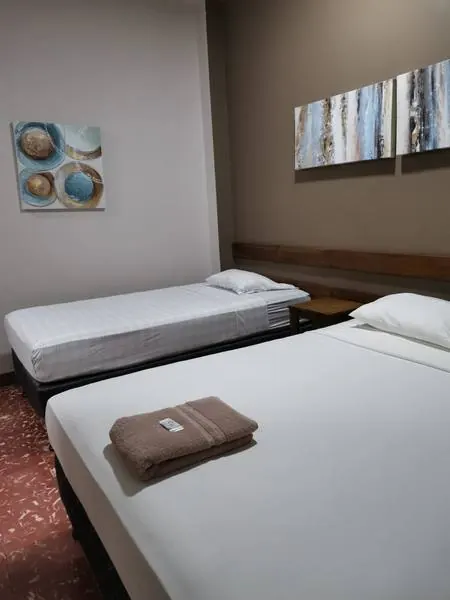 Habitación con dos camas y piso de baldosa